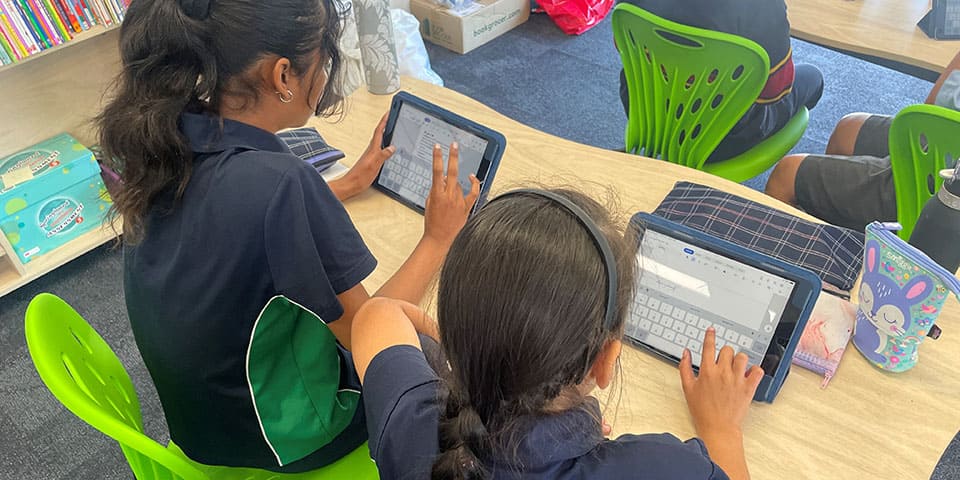 Two Girls Typing on the Tablet