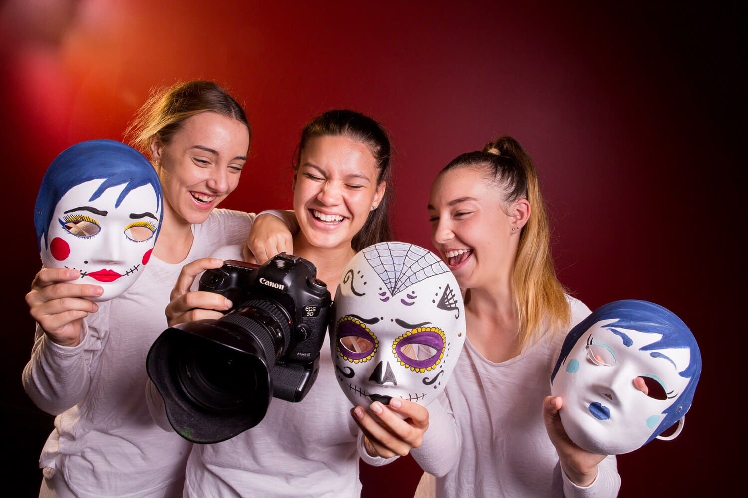 Girls Laughing at Camera While Holding Masks