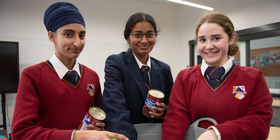 Three Female Students Sorting Cans Together